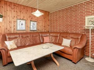 sala de estar con sofá de cuero marrón y mesa en 6 person holiday home in Bindslev, en Bindslev