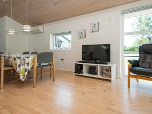 sala de estar con mesa y TV de pantalla plana en Holiday home Glesborg XXXIII, en Glesborg