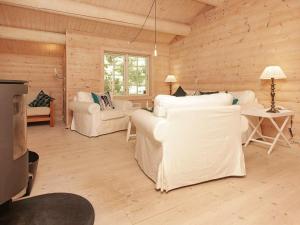 8 person holiday home in Frederiksv rk في Frederiksværk: غرفة معيشة مع أرائك بيضاء وتلفزيون