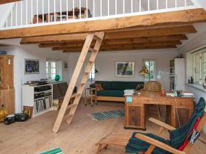 a loft bed in a living room with a desk at 7 person holiday home in Bredebro-By Traum in Ballum +12 photos