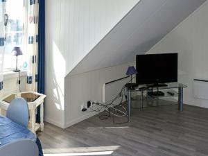 a living room with a flat screen tv in a attic at Apartment Onarheim II in Onarheim