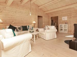 8 person holiday home in Frederiksv rk في Frederiksværk: غرفة معيشة بأثاث أبيض وجدران خشبية