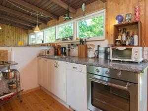 a kitchen with a stove and a microwave at 4 person holiday home in Grenaa in Grenå