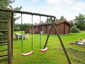 a swing set in a yard with a house at 6 person holiday home in F rvang in Fårvang