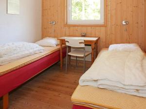 Hadsundにある6 person holiday home in Hadsundのベッド2台、デスク、テーブルが備わる客室です。
