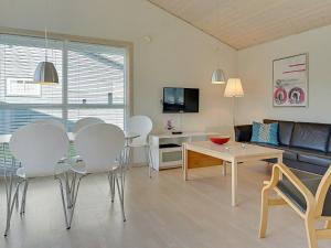 uma sala de estar com uma mesa e cadeiras e um sofá em 6 person holiday home in Gudhjem em Gudhjem