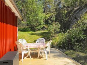 una mesa y sillas en un porche con mesa y sillas en 4 person holiday home in HEN N, en Nösund