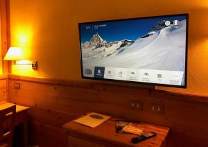 a flat screen tv hanging on a wall at Hotel Mignon in Breuil-Cervinia