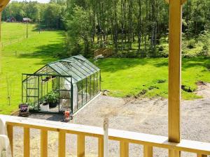 Åsljungaにある4 person holiday home in sljungaの柵の横の庭の緑の温室