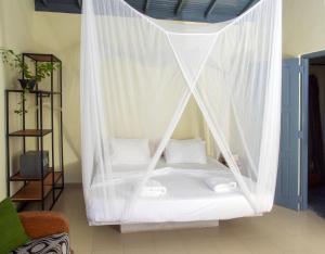 uma cama num quarto com redes mosquiteiras brancas em Secret Garden Galle Fort em Galle