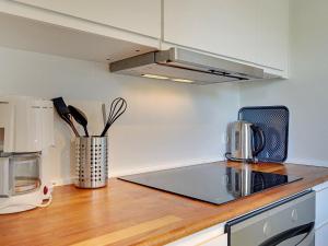 uma cozinha com um balcão com um lavatório e um micro-ondas em 6 person holiday home in Gudhjem em Gudhjem