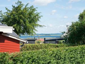 een rood huis met uitzicht op het water bij 7 person holiday home in Juelsminde in Snaptun