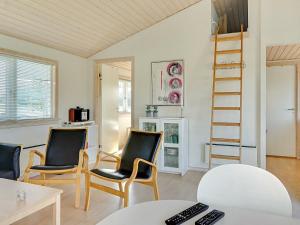 uma sala de estar com duas cadeiras e uma escada em 6 person holiday home in Gudhjem em Gudhjem