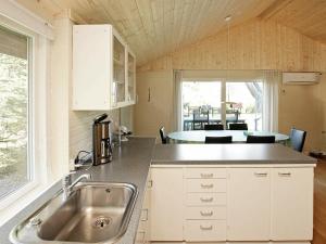 Fjand Gårdeにある6 person holiday home in Ulfborgのキッチン(シンク、テーブル、椅子付)