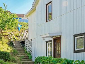a white house with stairs leading up to it at 5 person holiday home in DYR N in Stora Dyrön