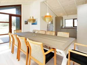 a dining room with a wooden table and chairs at Holiday Home Kandestedvej in Starholm