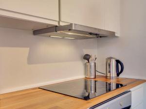 a kitchen with a stove top oven next to a microwave at 6 person holiday home in Gudhjem in Gudhjem