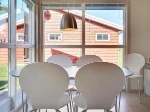 een eetkamer met een witte tafel en stoelen bij 6 person holiday home in Gudhjem in Gudhjem