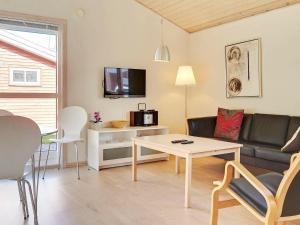 uma sala de estar com um sofá e uma mesa em 6 person holiday home in Gudhjem em Gudhjem