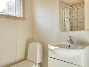 a white bathroom with a sink and a toilet at 6 person holiday home in Gudhjem in Gudhjem