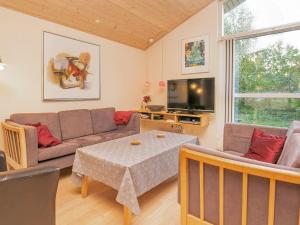 a living room with a couch and a table and a tv at 6 person holiday home in Ringk bing in Ringkøbing