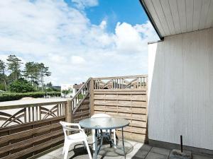 d'une terrasse avec une table et des chaises sur un balcon. dans l'établissement 4 person holiday home in R m, à Rømø Kirkeby