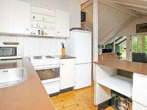 a kitchen with white appliances and a wooden floor at 6 person holiday home in R dby in Rødby