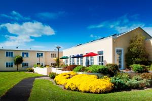 a building with yellow flowers in a yard at Park Inn by Radisson Shannon Airport in Shannon