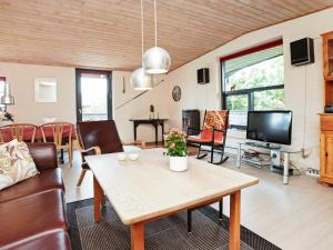 Nørre Vorupørにある6 person holiday home in Thistedのリビングルーム(テーブル、テレビ付)