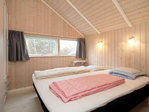 a bedroom with a large bed with pink towels on it at 6 person holiday home in Nykøbing Sj-By Traum in Lumsås