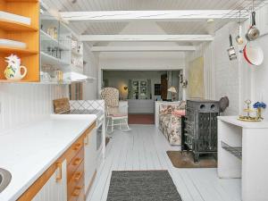 a kitchen with a stove and a dining room at 6 person holiday home in R dby in Rødby
