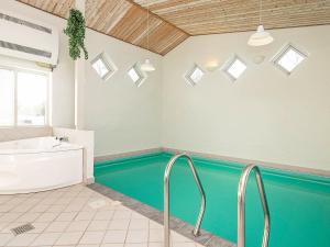 a bathroom with a swimming pool and a tub at Holiday Home Helmklit II in Fjand Gårde