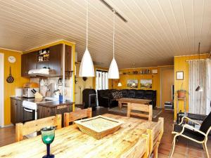 uma cozinha e sala de estar com uma mesa de madeira em Three-Bedroom Holiday home in Henne 9 em Henne Strand