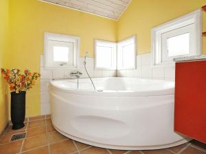 - Baño con bañera blanca y 2 ventanas en 10 person holiday home in Hadsund, en Odde