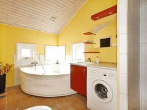 y baño con bañera y lavadora. en 10 person holiday home in Hadsund, en Odde