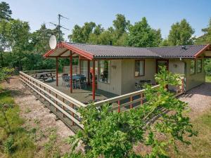 een huis met een houten terras met een tafel bij 6 person holiday home in Aakirkeby in Vester Sømarken