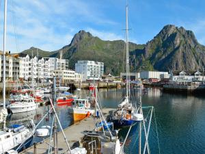 a group of boats docked in a harbor with a mountain at 6 person holiday home in Svolv r in Svolvær