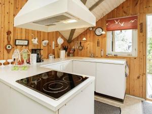 Oksbølにある6 person holiday home in Oksb lのキッチン(白いキャビネット、コンロ付)