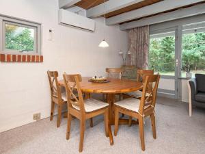 a dining room with a wooden table and chairs at 5 person holiday home in Ebeltoft in Øksenmølle