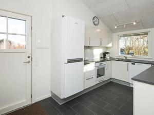 a white kitchen with white appliances and a window at 8 person holiday home in B rkop in Egeskov