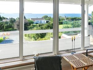 a room with large windows looking out at the ocean at 8 person holiday home in Ebeltoft in Ebeltoft