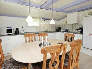 een keuken met een ronde houten tafel en stoelen bij 6 person holiday home in L kken in Løkken