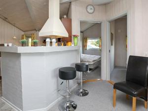 Zimmer mit einer Bar mit 2 Stühlen und einem Bett in der Unterkunft 8 person holiday home in Bl vand in Blåvand