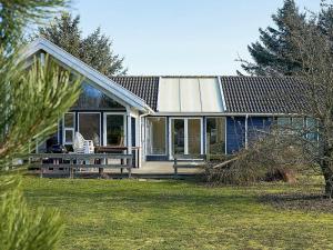 a small house with a porch and a lawn at 12 person holiday home in Aakirkeby in Vester Sømarken