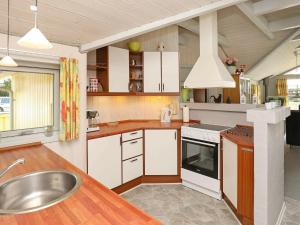 eine Küche mit weißen Schränken und einem Waschbecken in der Unterkunft 8 person holiday home in Bl vand in Blåvand