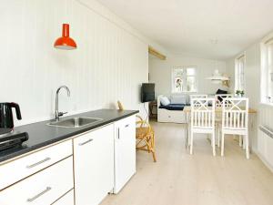 a kitchen with a sink and a table with a bed at 4 person holiday home in Skagen-By Traum in Skagen +23 photos