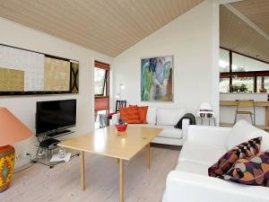 6 person holiday home in Hirtshals في هيرتسهلس: غرفة معيشة مع أريكة بيضاء وطاولة