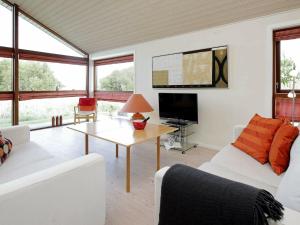 ヒアツハルスにある6 person holiday home in Hirtshalsのリビングルーム(白い家具、テレビ付)