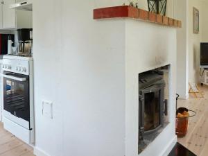 a white fireplace in a kitchen with an oven at Holiday home BORÅS in Borås
