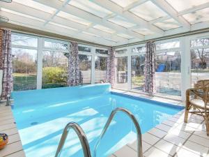 uma piscina num quarto com janelas em 7 person holiday home in rsted em Kare